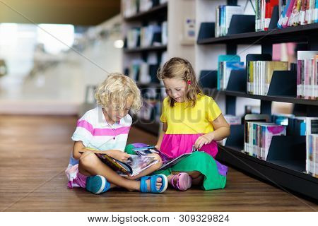 Child In School Library. Kids Reading Books.