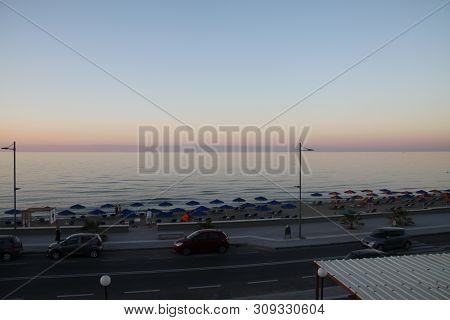 Pink And Blue Sunset On A City Beach