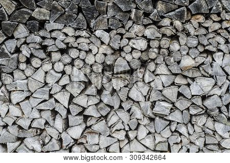 Background Of Splitted, Dried And Stacked Firewood. Bunch Of Wood. Black And White Photo.