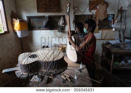 Gianyar,bali/indonesia-may 30 2019: A Guitar Craftsman Is Measuring And Make Sure It Is Precision In