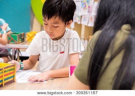 Kids Are Painting Picture With Color Pencil With Their Teacher In The Classroom To Learn Paint Skill
