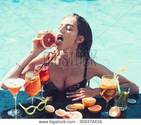 Young Woman Reaxing On The Deck By The Swimming Pool At Exotic Resort