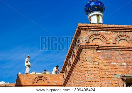 Ilinskoe, Russia - August 2018: Migrant Workers Build A Russian Orthodox Church In The Village Of Il