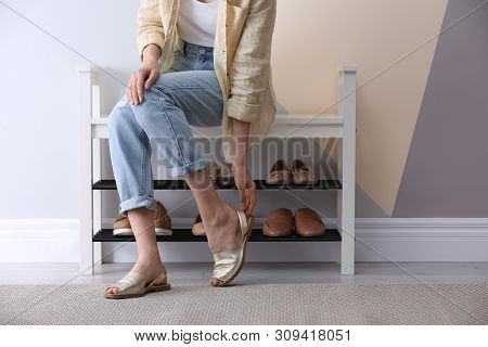 Woman Putting On Shoes Indoors, Closeup. Stylish Hallway Interior