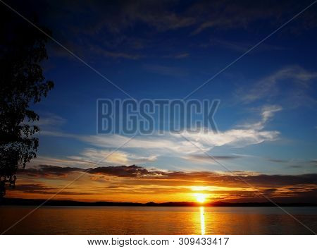 Darkening Sunset Sky Over The Lake With Colorful Clouds, Golden Hour, Path From The Sun, The Souther