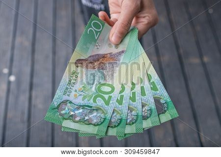 Cropped Shot View Of Someone Showing The Money (new Zealand 20$ Dollars). New Zealand Dollar Is The 