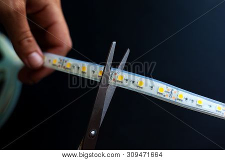 Cut Led Strip With Scissors For Mounting On A Dark Background Close-up