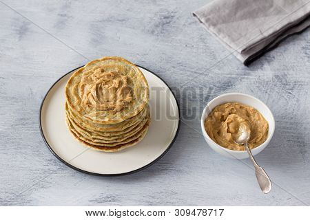 Vegan Pancakes With Flax Seeds, Peanut Butter And Vegan Milk On A White Plate On A Gray Background. 