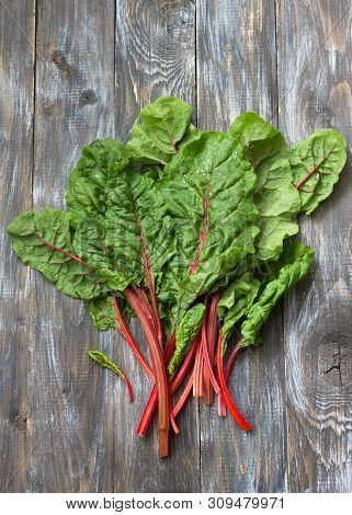 Fresh Raw Leaves Of Chard, Leaf Beets, Mangold, Swiss Chard On A Wooden Table, Close Up, Free Space