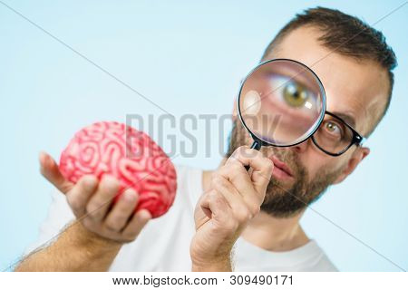 Adult Nerd Man Wearing Eyeglasses Looking At Human Brain Model. Thinking And Intelligence Conept