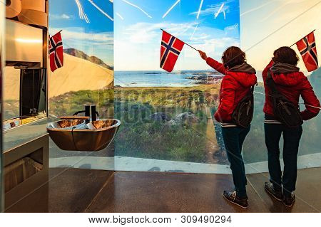Tourist Woman With Norwegian Flag Enjoying Sea Coast View From Inside Of Mirrored Toilet Bukkekjerka