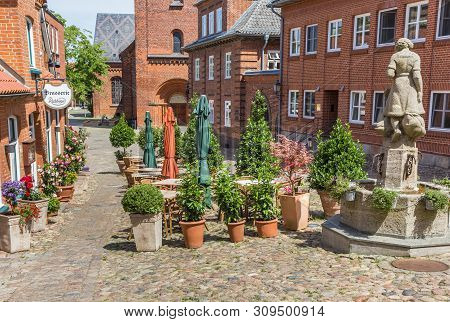 Plon, Germany - June 24, 2019: Statue And Restaurant At The Market Square Of Plon, Germany