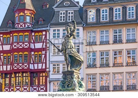 Lady Justice Standing At The Fountain Under Blue Sky In Frankfurt As A Symbol Of Justice
