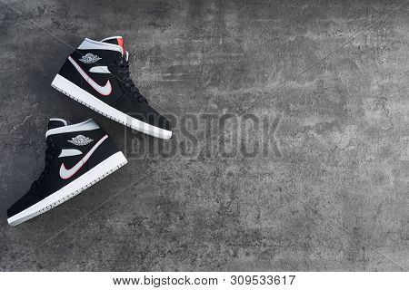Vienna, Austria - May 10, 2019: Nike Air Jordan 1 Mid Black, Grey, Red And White Sneakers On Dark Co