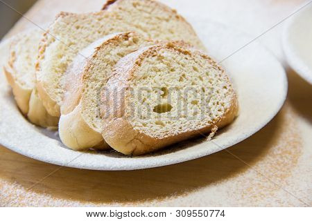 Poudered Slices Of Bread In A White Plate On The Wooden Table