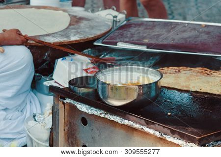 Turkish Woman Prepares Gozleme - Traditional Dish In The Form Of Flatbread Stuffed With Greens And C