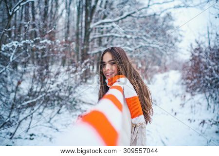 Winter Portrait Of Young Woman In The Winter Snowy Scenery. Portrait Of A Young Woman In Snow Trying