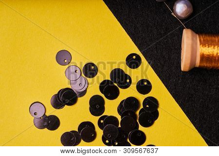 Embroidery Products And Tools. Coil With Metallic Thread, Pearls And Sequins On Black Felt.