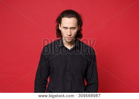 Shocked Upset Stylish Young Curly Long Haired Man In Black Shirt Posing Isolated On Red Wall Backgro