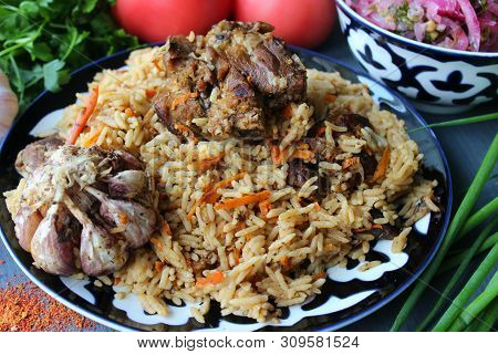 Pilaf On A Platter Of Meat And Spices.pilaf In A Plate On A Wooden Background, Top View.  The Concep