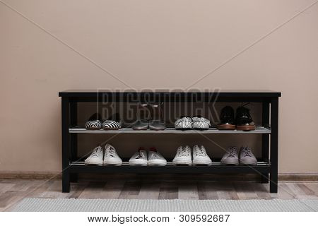 Shoe Rack With Different Footwear Near Color Wall. Stylish Hallway Interior