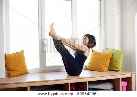 Young Attractive Woman Practicing Yoga, Sitting In Boat Pose Exercise, Paripurna Navasana, Workout, 