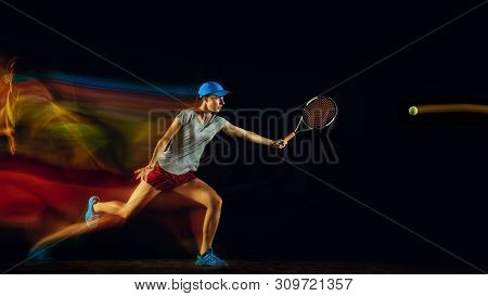 One Caucasian Woman Playing Tennis Isolated On Black Background In Mixed And Stobe Light. Fit Young 