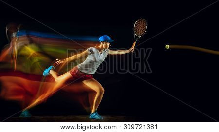 One Caucasian Woman Playing Tennis Isolated On Black Background In Mixed And Stobe Light. Fit Young 