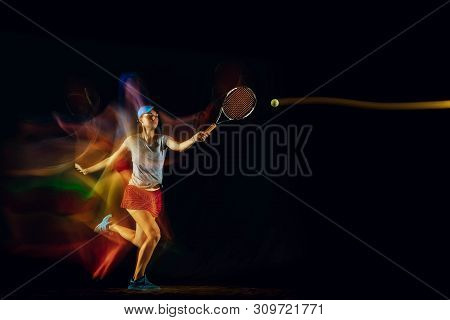 One Caucasian Woman Playing Tennis Isolated On Black Background In Mixed And Stobe Light. Fit Young 