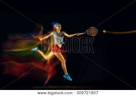 One Caucasian Woman Playing Tennis Isolated On Black Background In Mixed And Stobe Light. Fit Young 