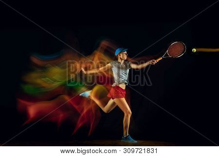 One Caucasian Woman Playing Tennis Isolated On Black Background In Mixed And Stobe Light. Fit Young 