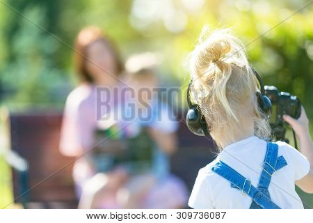 Girl Novice Videoblogger Shoots At The Camera, Defocus. The Child Makes His First Videos On The Stre
