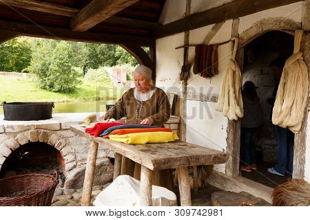 Sundby Lolland, Denmark - August 21, 2017 - The Senior Woman In Medieval House With Fabric Materials
