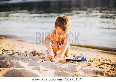 Kids Play On Beach. Sand And Water Toy. Truck Toy Car With Sand And Soil. Green Environment Construc