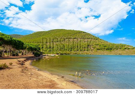 View Of Gulf, Pier And Beach Of Tramariglio In A Sunny And Cloudy Day, In The Capocaccia Coast