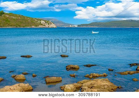 View Of Gulf, Pier And Beach Of Tramariglio In A Sunny And Cloudy Day, In The Capocaccia Coast