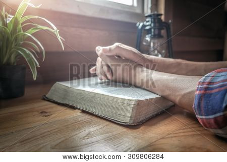Focus At Beside Of Holy Bible With Hands Praying Background.