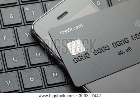 Black Style. Credit Card And Mobile Phone Smartphone On The Keyboard With Laptop. Online Payment For