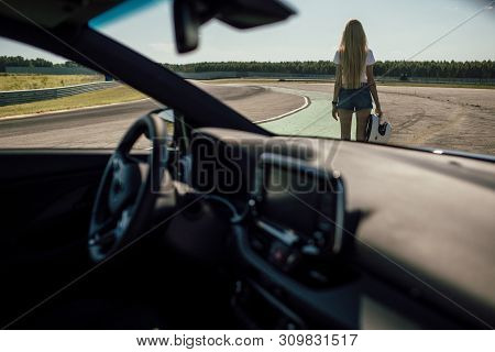 Girl On The Race Track. Holding Helmet