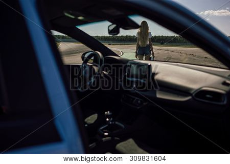 Girl On The Race Track. Holding Helmet