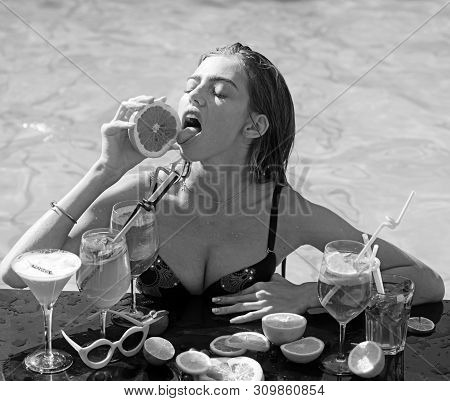 Young Woman Reaxing On The Deck By The Swimming Pool At Exotic Resort