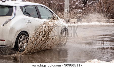 The Car B Stro Drives Through A Puddle Of Dirt, Sprays Fly From Under The Wheels