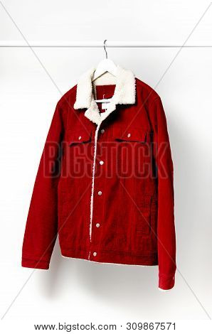 Red Corduroy Men's Jacket On White Coat Hanger On Rod Against Light Wall Flat Lay Copy Space. Male F