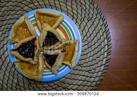 Hamantash Purim Blueberry And Apricot Jam Cookies In Colored Plate With Wooden Table Background