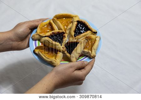 Woman Hands Holding Colorful Plate With Apricot And Blueberry Hamantash Purim Cookies