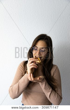 Beautiful And Happy Women Portrait Eating Hamantash Purim Apricot Cookie