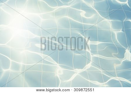 Water Vibrations In The Swimming Pool With Sun Reflection. Blue Swimming Pool Surface, Water Backgro