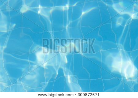 Water Vibrations In The Swimming Pool With Sun Reflection. Blue Swimming Pool Surface, Water Backgro