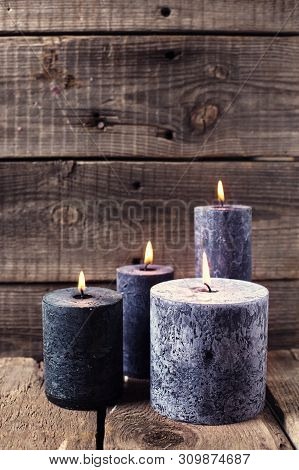 Black  Burning Candles  On Aged Wooden Textured Background. Spa Or Still Life Concept. Selective Foc