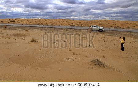 Turkmenistan, Karakum Desert.  March 21, 2019: The Girl Takes A Selfie On The Background Of The Sand